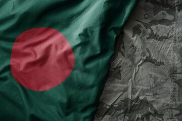 waving flag of bangladesh on the old khaki texture background. military concept.