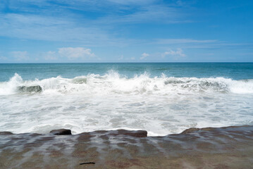 flat rocks that look like sand from a distance make up a coastal beach with vigorous ocean energy...