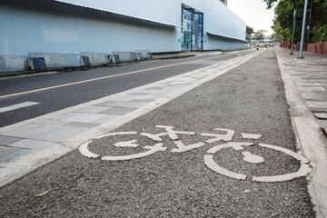 View of bicycle icon symbol on bicycle lane on the road of downtown in Bangkok, Thailand. Cycling friendly city in Thailand.  - obrazy, fototapety, plakaty