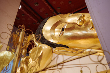 Interior view inside the temple at Wat Phra Non Chak Si Worawihan, Selective focus detail of buddha statue in sleeping pose. 