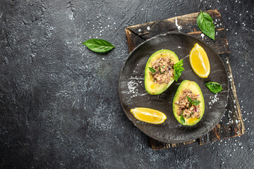 Avocado stuffed with tuna. Ketogenic diet. Low carb high fat breakfast. Healthy food concept. place...