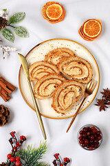 Homemade winter dessert, stollen or strudel with sweet cream filling, nuts, cinnamon and poppy seeds. Concept for holiday bakery, seasonal treats and cafe advertising