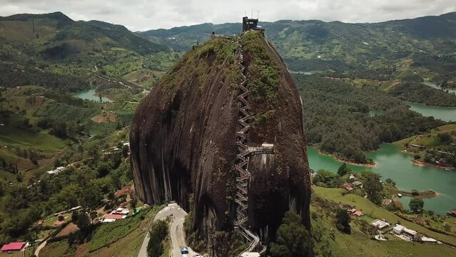 Aerial drone footage of El Penon de Guatape near Medellin in Antioquia, Colombia. Large and unique alone rock with stairs to the top, touristic place. Big stone in Colombia. High quality 4k footage.