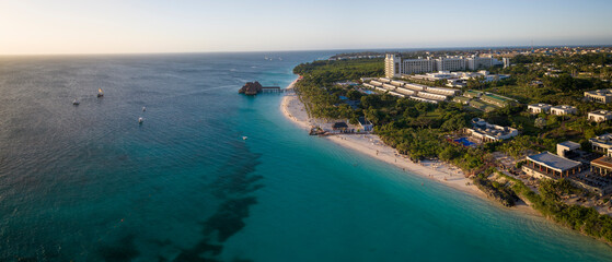 Fototapeta premium Aerial shot of Zanzibar beach where tourists and locals mix together of colors and joy, concept of summer vacation, aerial view of Kendwa beach, Tanzania