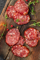 Thinly sliced salami or dry sausage on a wooden background. vertical image. place for text