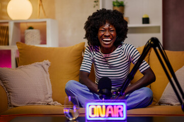 African american woman laughing while recording episode of an internet podcast