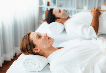 Obraz na płótnie Canvas Serene modern daylight ambiance of spa salon, couple customer indulges in rejuvenating with facial skincare mask. Facial skin treatment and beauty cosmetology procedure for face. Quiescent