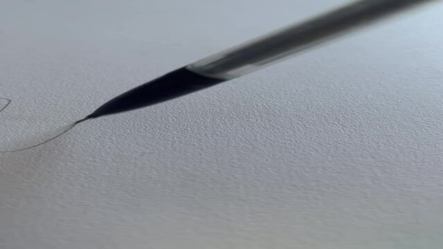 Mechanical pencil drawing a squiggly line on white paper
