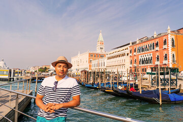 typed man traveler with hat in Venice Italy with gondolas and lagoon sea holidays 