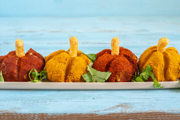 Mushed mixed vegetables in the form of Halloween pumpkin covered with orange and yellow spices...