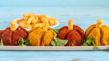 Mushed mixed vegetables in the form of Halloween pumpkin covered with orange and yellow spices...