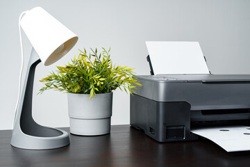 Printer with paper on gray background close up