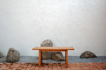 Minimalist Zen Corner: Wooden Bench with Serene Garden Rocks.