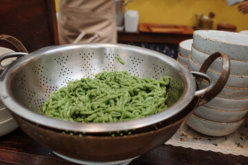 Close-up and top view at Lod Chong or Cendol, iced sweet dessert be famous in South East Asia, inside aluminium strainer be ready to serve. 