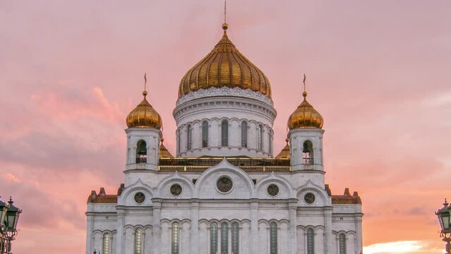 Majestic orthodox Cathedral of Christ Saviour with sunset on bank of Moscow river. It is tallest Orthodox church in world. Orange sky with clouds. Timelapse from the Patriarchal Bridge, Russia