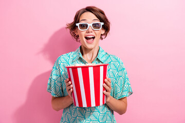 Photo of astonished overjoyed lady hands hold popcorn bucket watch movie 3d glasses isolated on...