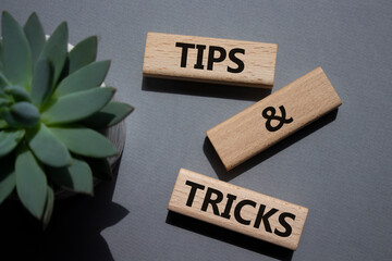 Tips and tricks symbol. Wooden blocks with words Tips and tricks. Beautiful grey background with...