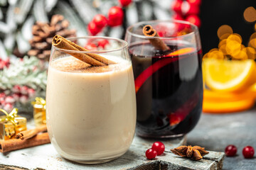 glasses of mulled wine and eggnog, Christmas winter alcohol drinks decorated by christmas lights