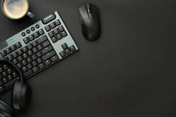 Headphones, computer mouse and keyboard on black background