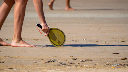 A beach game with a wooden racket and a ball.