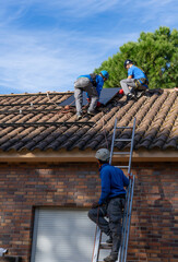 Three workers installing solar panels in a residence