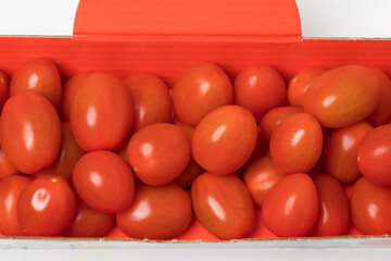 Small red cherry tomatoes on a white background.