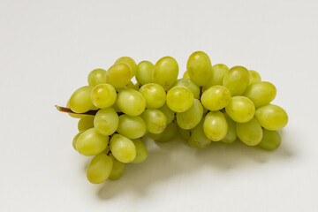 Healthy fruit. Balls of grape wine on a stem on a white background.