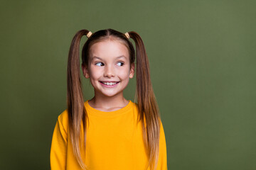 Photo of cheerful funny schoolgirl with ponytails wear yellow pullover look at sale empty space...