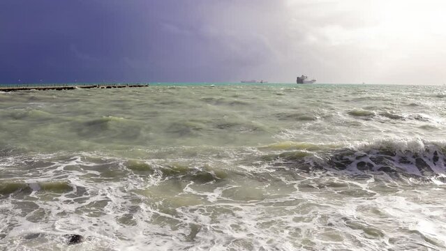 Crashing wave on Silifke coast under dramatic sky depicts sea storm. Dramatic sky above Silifke sea enhances crashing wave scenery. Silifke sea storm with crashing waves, dramatic sky visible