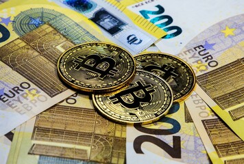Coins symbolizing Bitcoin and Euro banknotes. Virtual and real money