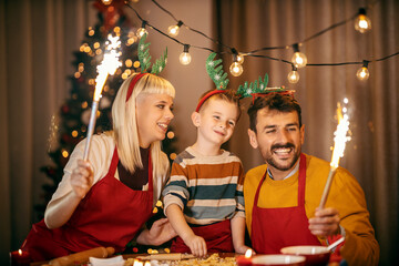 Portrait of a loving parents celebrating christmas and new year's eve with their son while holding...