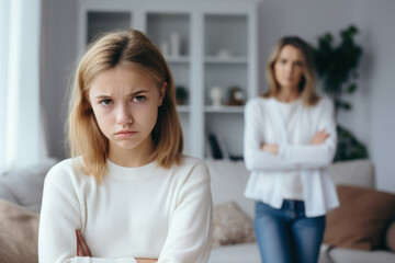 Close up upset girl in front and woman behind avoid to talk after quarrel at home, offended teen daughter and young aged mum argument, two generation conflict concept