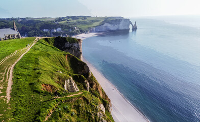 Awe drone point of view on sunset panorama of beach and steep slopes in Etretat town district  with...