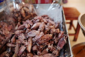 Pile of dry squid on the aluminium tray in front of stall market. 