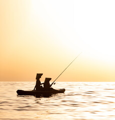 a woman with a child on a sup board in the sea swim against the background of a beautiful sunset,...