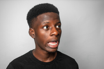 Happy cheerful young African gen Z isolated on white background. Funny confused state of mind and shock