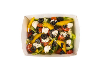 Delicious Greek salad in a lunchbox on a white background. Isolated.