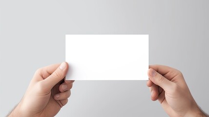 a man's hand holding a blank, simple white business card design mockup, the absence of text and the potential for business branding against a light background.