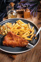 Fried cod fillet with fries and salad.