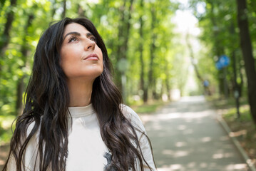 Relaxed woman breathing fresh air in a green summer forest