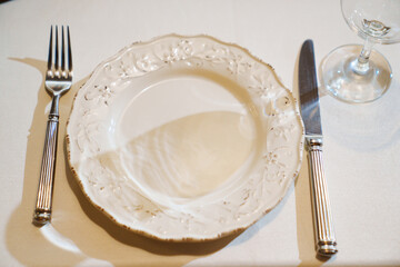 Top view. White plate in retro style with cutlery and glass.