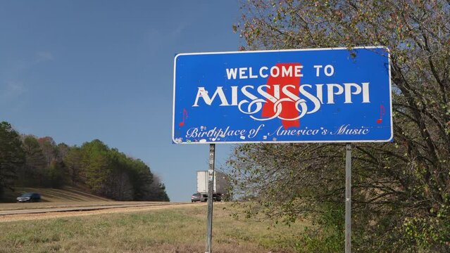 Welcome to Mississippi, Birthplace of America's Music - road sign at state border with Alabama in late fall scenery with highway traffic