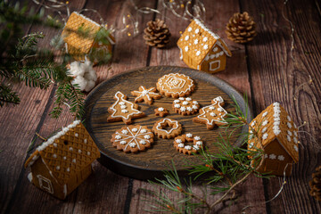 Gingerbread cookies decorated with icing on table surrounded by lights and pine 