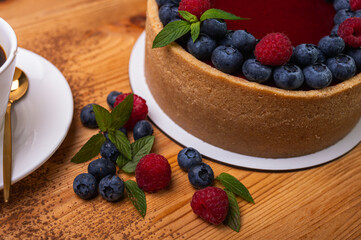 close-up of cheesecake with cream filling, decorated with fresh berries, blueberries and raspberries, festive New Year's cake, Christmas	