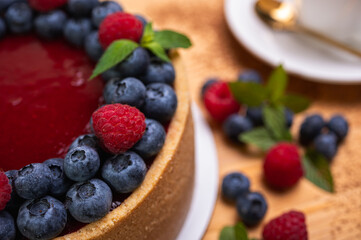 close-up of cheesecake with cream filling, decorated with fresh berries, blueberries and raspberries, festive New Year's cake, Christmas	