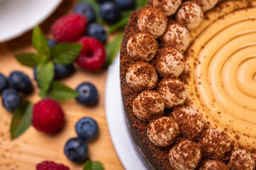 close-up of cheesecake with cream filling, decorated with fresh berries, blueberries and raspberries, festive New Year's cake, Christmas	