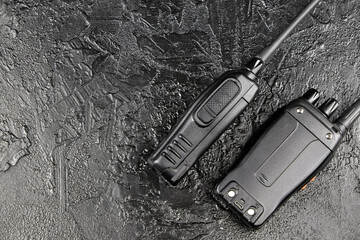 Pair of portable radio station on black graphite background, walkie-talkie. Security devices ....