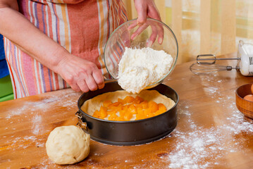 Chef pours batter into pan to prepare fruit cheesecake.