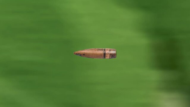 Firearms bullet 7,62 mm caliber flies on forest background.
