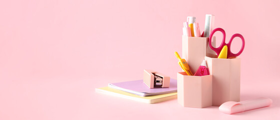 Holder with different stationery on pink background with space for text